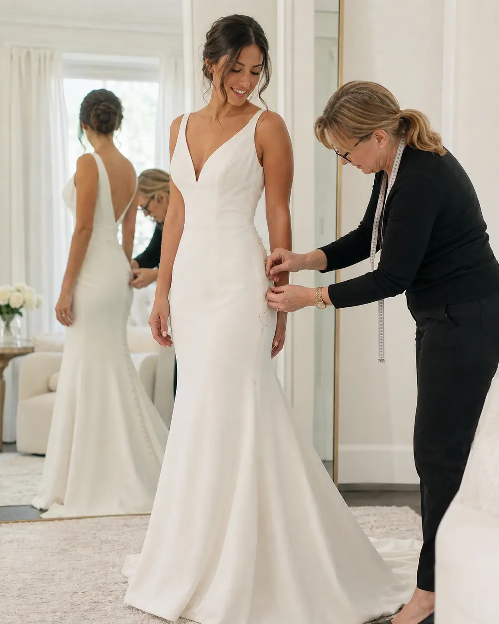 fit-and-flare-wedding-dress-alterations Seamstress altering a fit-and-flare wedding dress